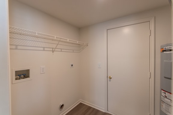 This is a photo of the utility room with full-size washer and dryer connections of the 1500 square foot 3 bedroom, 2 and a half bath with 2-car garage Bellbrook floor plan at Washington Park Apartments in Centerville, OH.