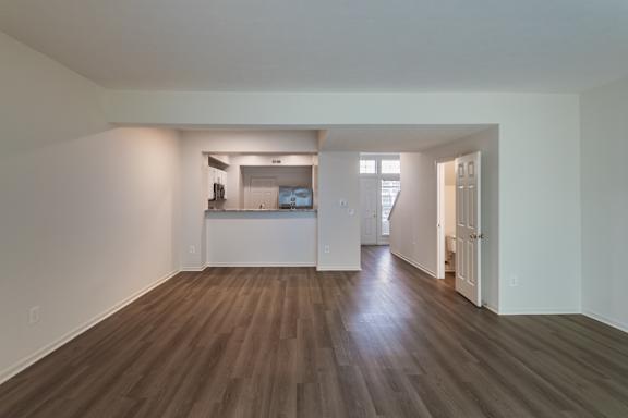 The large, open living room looking towards the kitchen in the 1280 square foot, 2 bedroom, 2 and a half bath Oakwood floor plan  at Washington Park Apartments, in Centerville, OH.