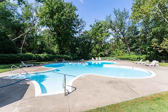 A large outdoor swimming pool surrounded by trees.at Grant Meadows Apartments, Philadelphia Pennsylvania