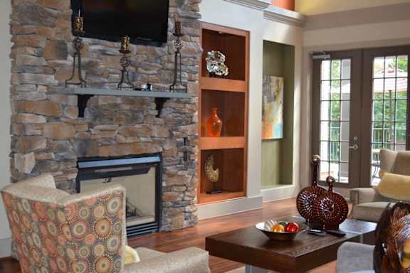 A living room with a stone fireplace and a chair at Riverview Landing @ Valley Forge, Eagleville Pennsylvania
