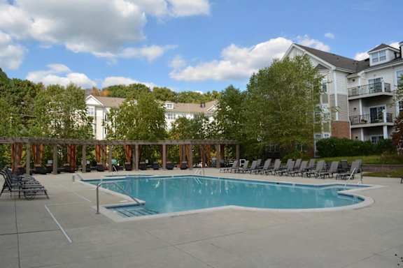 A large swimming pool surrounded by lounge chairs and trees.at Riverview Landing @ Valley Forge, Pennsylvania, 19403