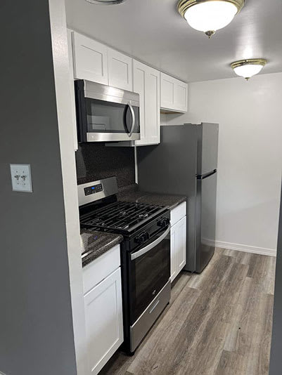 a kitchen with a stove microwave and refrigerator at Franklin Square Townhomes, Philadelphia