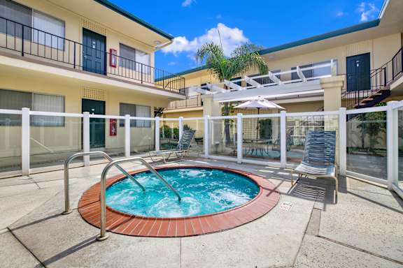 a jacuzzi in the middle of a pool in front of a building
