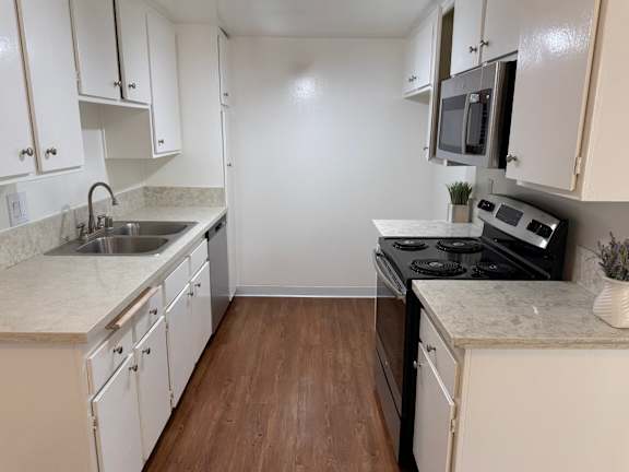A kitchen with white cabinets and a black stove top oven.