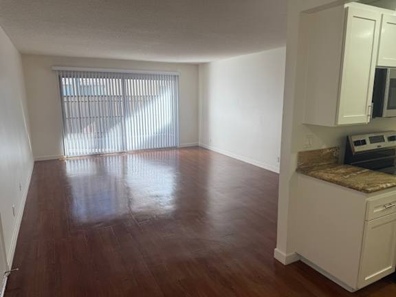 A kitchen with white cabinets and a brown floor.