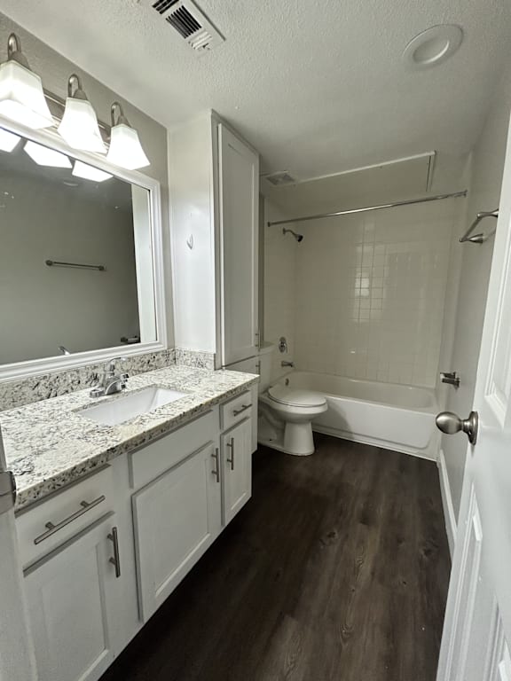 A bathroom with a sink, toilet, and bathtub.