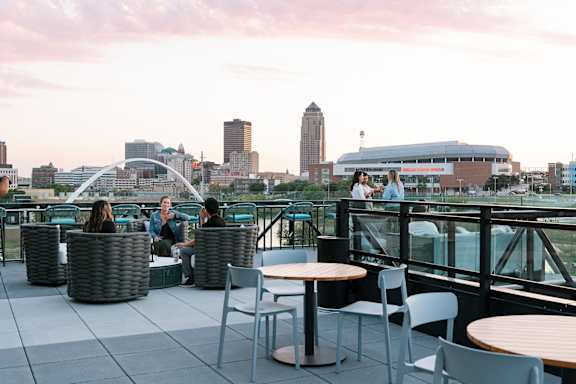 A group of people are sitting on a rooftop terrace.at Level, Des Moines, IA