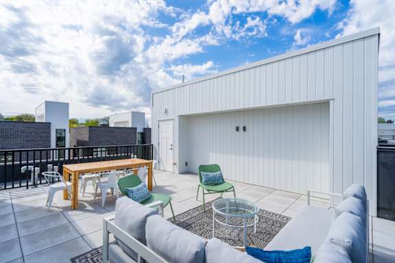 a patio with a couch and chairs and a table at Matilda 235 Townhomes, Des Moines