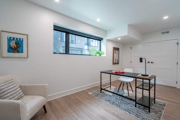 a living room with a desk and a chair and a window at Matilda 235 Townhomes, Des Moines, 50309