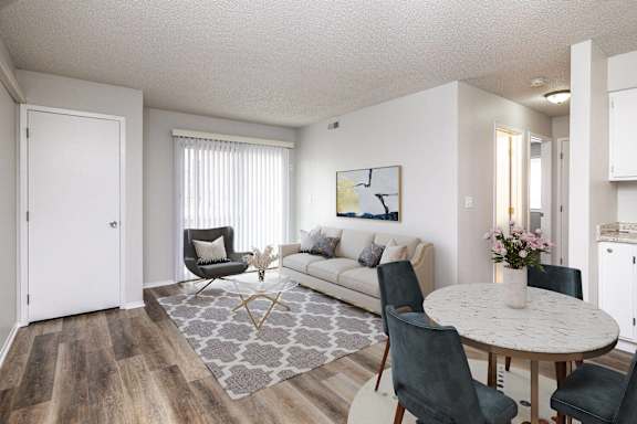 A living room with a white couch, a grey rug, and a round table with chairs.at Fish Creek, Iowa