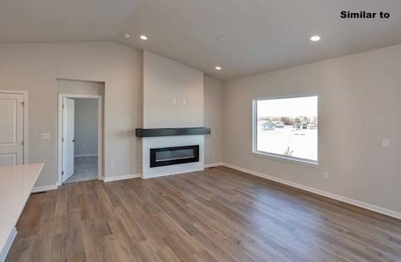 A spacious room with a fireplace and wood flooring. at Two Rivers Home Rentals, Iowa