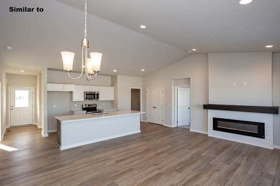 a large white kitchen with a fireplace and a table at Two Rivers Home Rentals, West Des Moines, IA