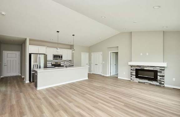 an empty living room with a kitchen and a fireplace at Two Rivers Home Rentals, Iowa 50266
