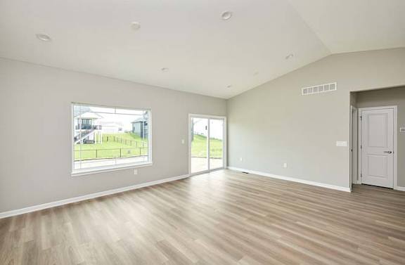 an empty living room with a large window and a door at Two Rivers Home Rentals, West Des Moines, IA