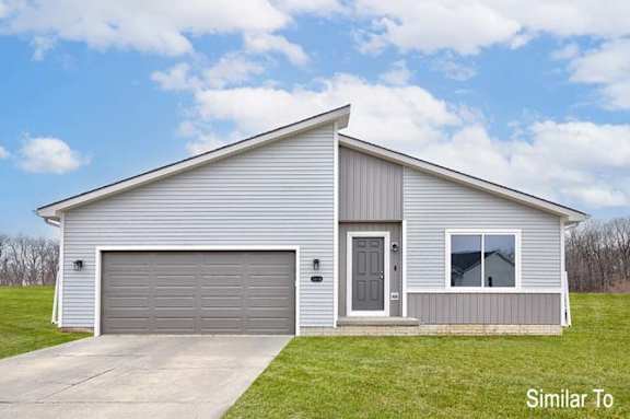 a white house with a driveway and a garage door at Two Rivers Home Rentals, Iowa 50266
