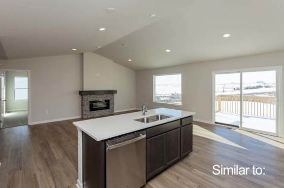 a kitchen with a sink and a stove and a fireplace at Two Rivers Home Rentals, West Des Moines, Iowa