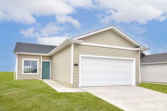 a tan house with a white garage door at Two Rivers Home Rentals, West Des Moines, IA
