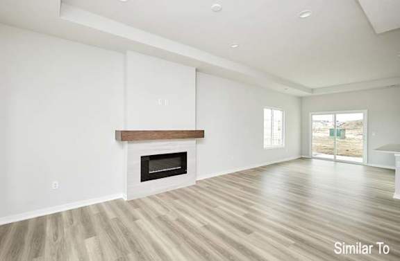 an empty living room with a fireplace and white walls at Two Rivers Home Rentals, West Des Moines, 50266