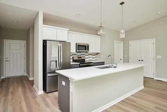 a large kitchen with a large white counter top at Two Rivers Home Rentals, West Des Moines, IA 50266
