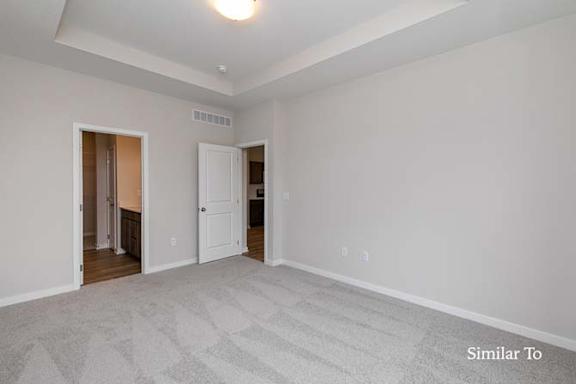 A room with a carpeted floor and a ceiling fan. at Two Rivers Home Rentals, Iowa 50266