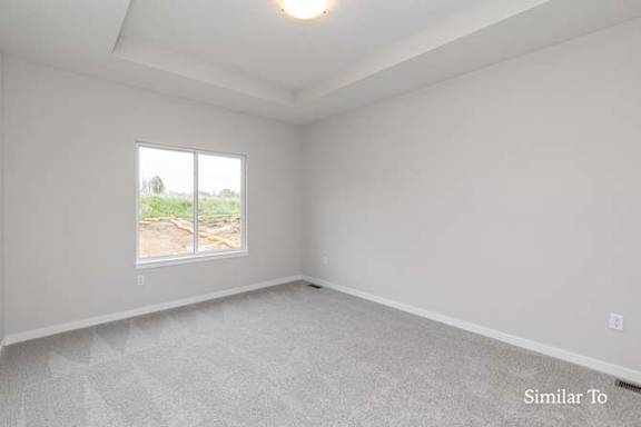 A room with a large window and a carpeted floor. at Two Rivers Home Rentals, West Des Moines, Iowa