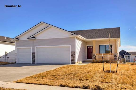 a white house with a porch and a driveway at Two Rivers Home Rentals, Iowa