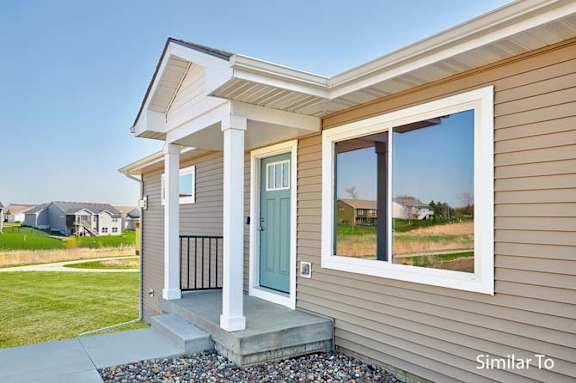 a house with a blue door and a large window at Two Rivers Home Rentals, West Des Moines, 50266