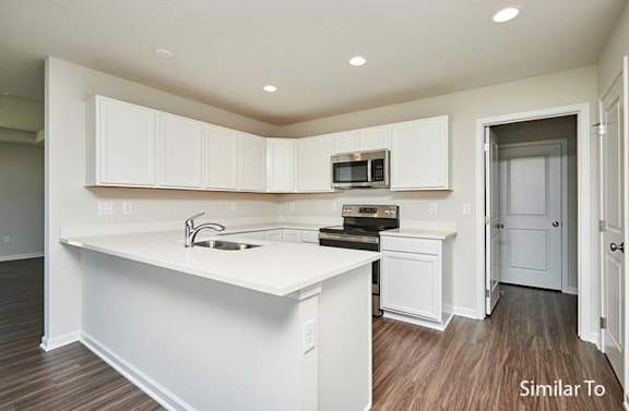 a white kitchen with a sink and a microwave at Two Rivers Home Rentals, West Des Moines