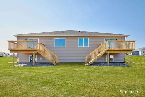 a house with two decks on the grass at Two Rivers Home Rentals, West Des Moines, IA