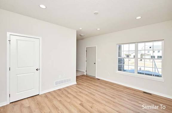 an empty living room with a door and a window at Two Rivers Home Rentals, Iowa 50266