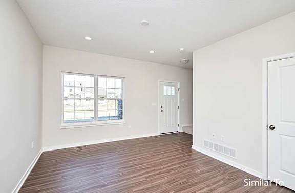 an empty living room with a door and a window at Two Rivers Home Rentals, West Des Moines