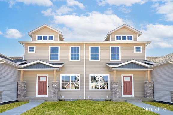 a beige house with red doors and windows at Two Rivers Home Rentals, West Des Moines, Iowa