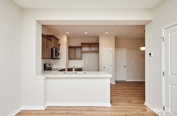 A kitchen with white cabinets and a white countertop. at Two Rivers Home Rentals, West Des Moines