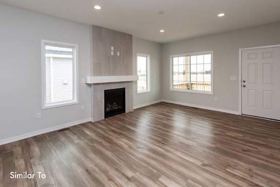 a living room with a fireplace and a wooden floor at Two Rivers Home Rentals, West Des Moines, IA