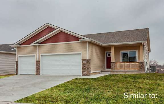 a beige house with a porch and a driveway at Two Rivers Home Rentals, West Des Moines, Iowa