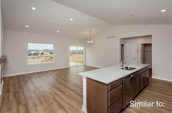 an empty kitchen with an island in the middle of it at Two Rivers Home Rentals, Iowa