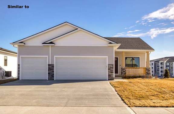 a white house with a white garage door at Two Rivers Home Rentals, Iowa 50266