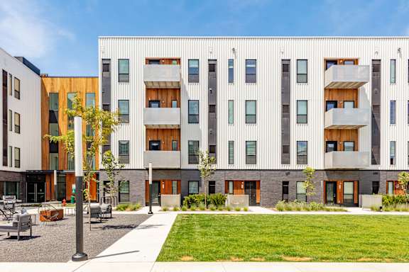 A modern building with a courtyard in front.at Rowat Lofts, Des Moines, 50309