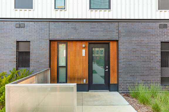 A modern building with a wooden door and windows.at Rowat Lofts, Des Moines