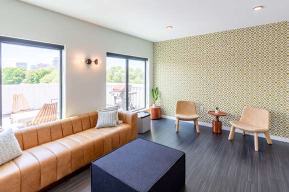A living room with a brown sofa and a black table.at Rowat Lofts, Iowa