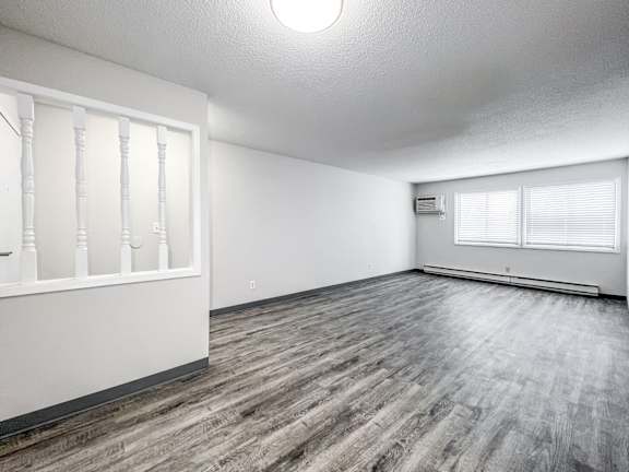 A room with wooden flooring and white walls at The Ridges Apartments, Iowa, 50315