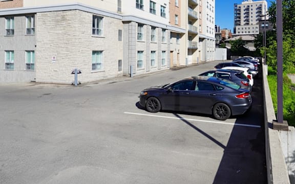 A car is parked in a parking lot in front of a building.