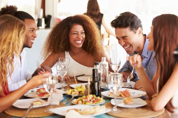 a group of people sitting around a table eating food