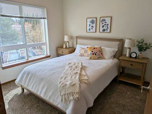 Bedroom with window overlooking trees at Ovation at Paine Field