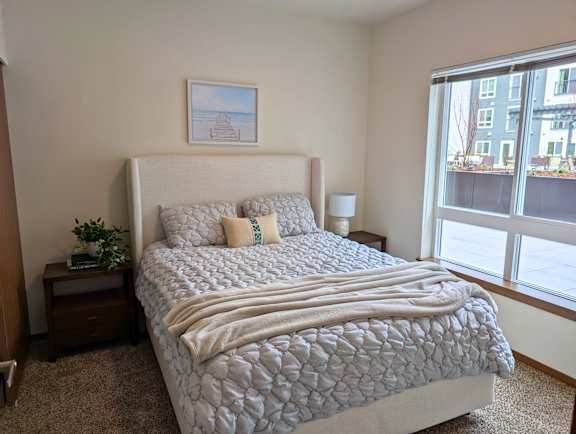 Model bedroom with large window at Ovation at Paine Field