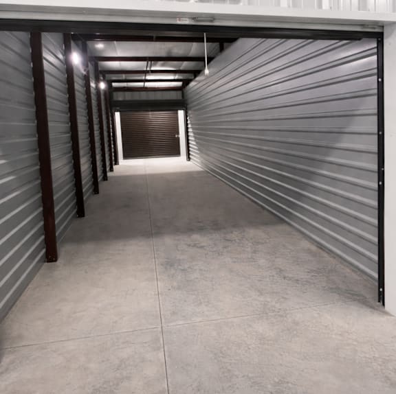 A long, narrow storage unit with a grey floor and walls.