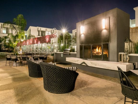 a patio with tables and chairs at night