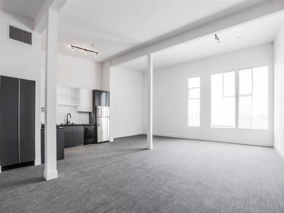 an empty living room with a kitchen in it