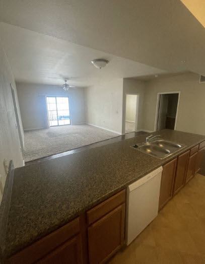 an empty kitchen with a counter and a sink