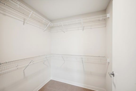 an empty room with white walls and a mirrored closet
